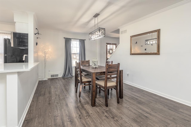 dining space featuring ornamental molding and dark hardwood / wood-style floors