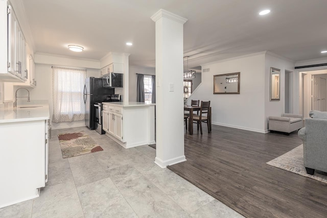 kitchen with white cabinetry, sink, ornamental molding, and appliances with stainless steel finishes