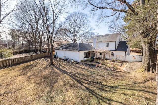 rear view of property with cooling unit and a yard