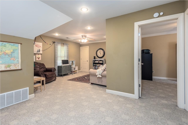 living room with crown molding, light colored carpet, and ceiling fan