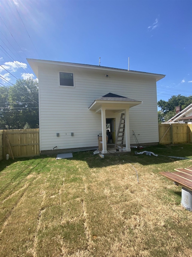 rear view of property featuring a yard