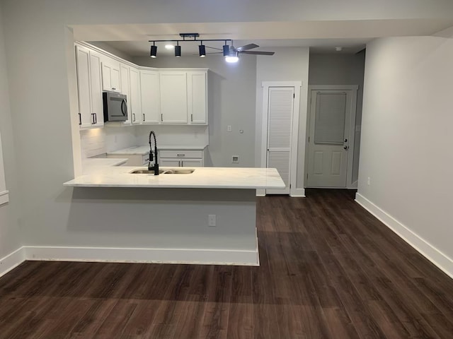 kitchen with sink, white cabinets, dark hardwood / wood-style flooring, ceiling fan, and kitchen peninsula