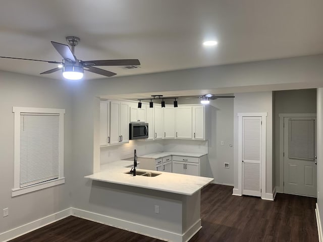 kitchen with sink, ceiling fan, dark hardwood / wood-style floors, white cabinets, and kitchen peninsula