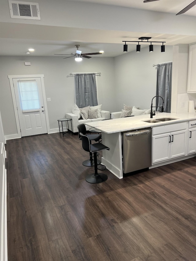 kitchen featuring dark wood-type flooring, stainless steel dishwasher, sink, and white cabinets