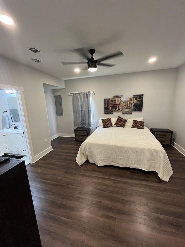 bedroom featuring dark wood-type flooring, ceiling fan, connected bathroom, and electric panel