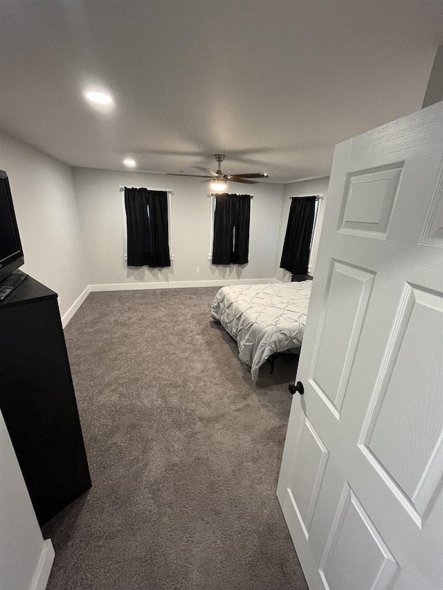 bedroom featuring ceiling fan and dark colored carpet