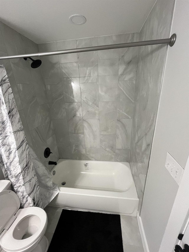 bathroom featuring tiled shower / bath and toilet