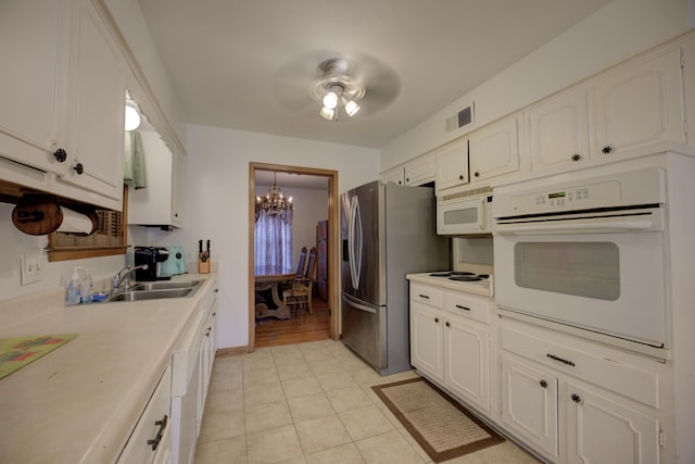 kitchen featuring white appliances, sink, and white cabinets