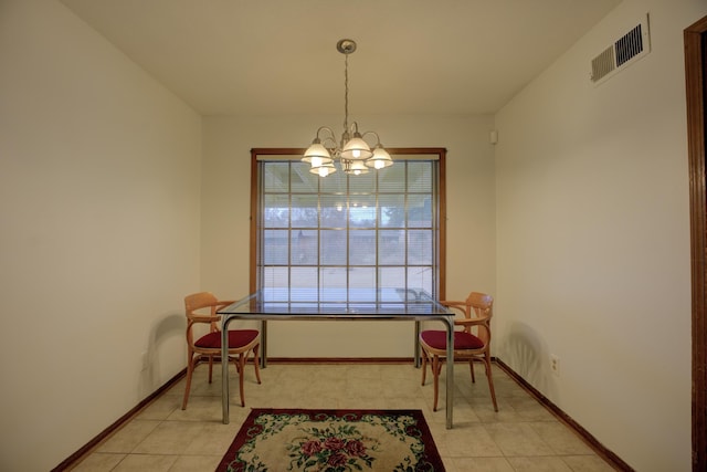 dining room with a chandelier and light tile patterned floors