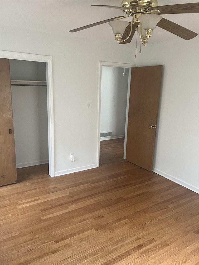 unfurnished bedroom featuring a closet, light wood-style flooring, ceiling fan, and baseboards