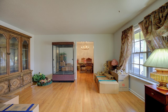 sitting room featuring a chandelier and light wood-type flooring