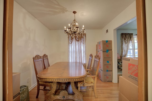 dining area featuring a notable chandelier and light wood-type flooring