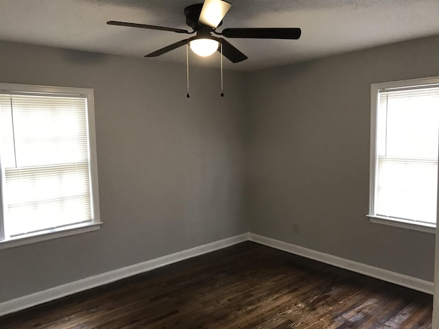 unfurnished room with plenty of natural light, dark hardwood / wood-style floors, and ceiling fan