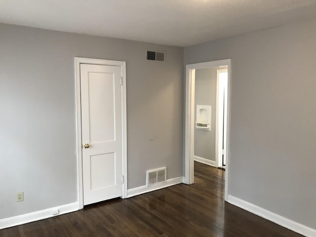 unfurnished bedroom featuring dark hardwood / wood-style flooring