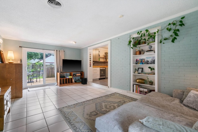 living room with light tile patterned floors, ornamental molding, a textured ceiling, and brick wall