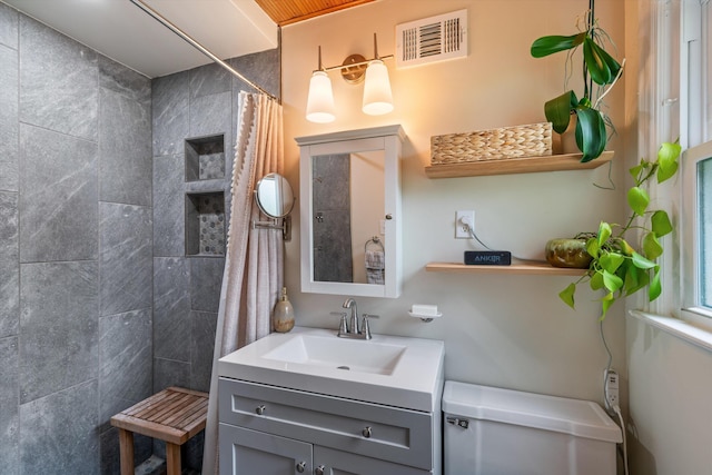 bathroom with vanity, curtained shower, and toilet