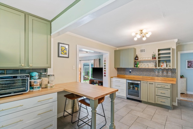 kitchen featuring butcher block countertops, crown molding, beverage cooler, and green cabinetry