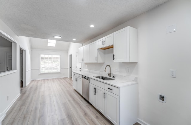 kitchen with vaulted ceiling, white cabinetry, sink, stainless steel dishwasher, and a textured ceiling