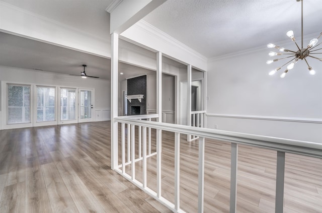 hall featuring an inviting chandelier, light hardwood / wood-style flooring, and ornamental molding