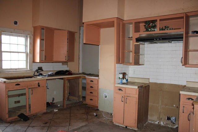 kitchen featuring tasteful backsplash, dark tile patterned floors, and sink