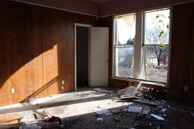 unfurnished room featuring wood walls