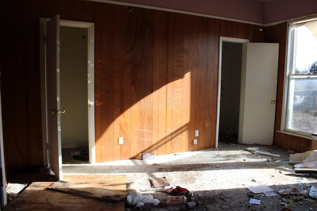 unfurnished room featuring wooden walls