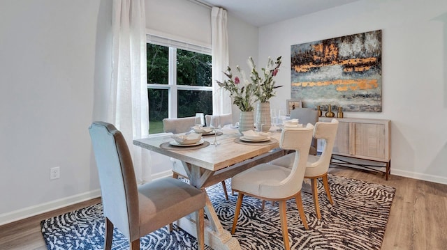 dining space with baseboards and wood finished floors