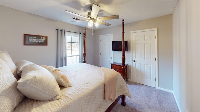 carpeted bedroom with ceiling fan and a textured ceiling