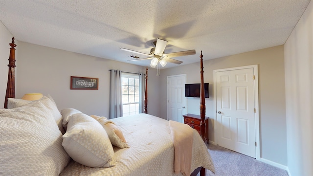 bedroom with a textured ceiling, carpet floors, and ceiling fan