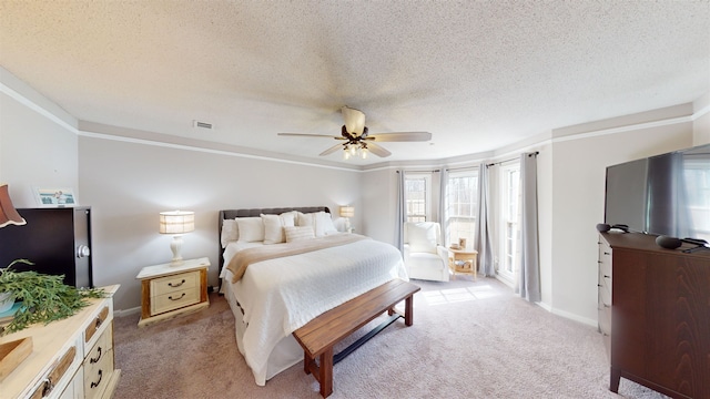 bedroom with ceiling fan, light colored carpet, and a textured ceiling