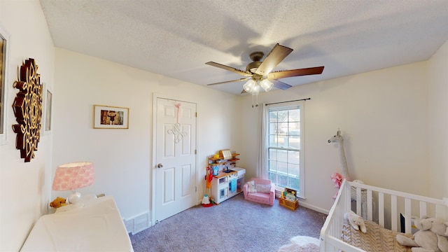 carpeted bedroom featuring ceiling fan and a textured ceiling