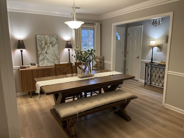 dining space featuring crown molding and wood-type flooring