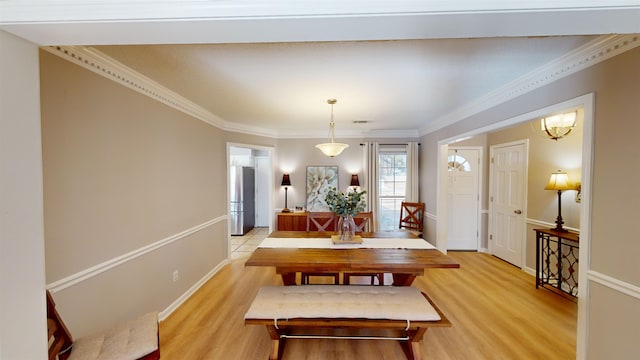 dining space featuring ornamental molding and light hardwood / wood-style floors