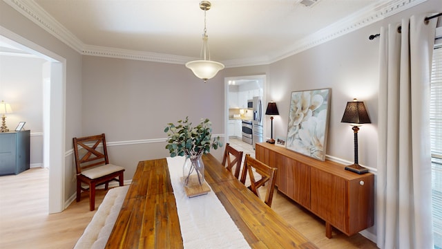 dining area with ornamental molding and light wood-type flooring