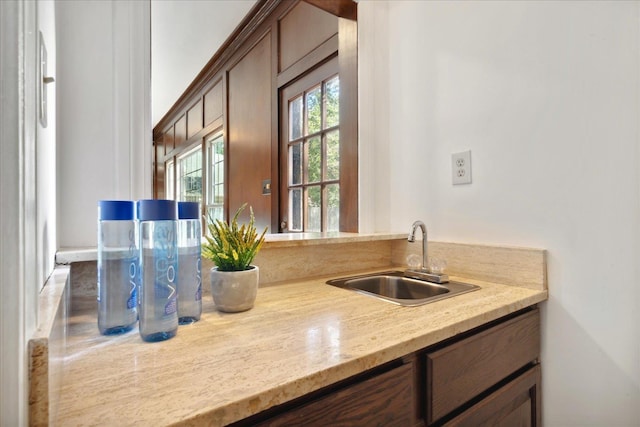 kitchen featuring light stone counters and sink