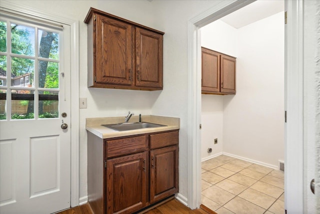 laundry room with cabinets, sink, hookup for an electric dryer, and light tile patterned floors