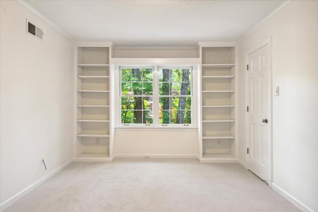 unfurnished bedroom with crown molding, light carpet, and a textured ceiling