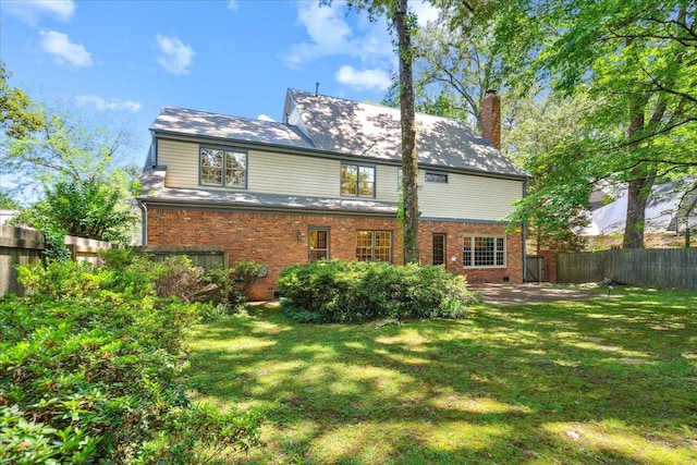 rear view of house with a yard and a patio area