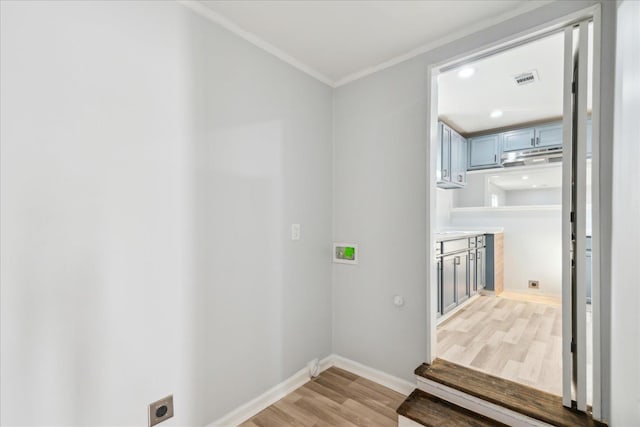 laundry area with crown molding, light hardwood / wood-style floors, and electric dryer hookup