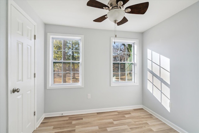 empty room featuring ceiling fan, plenty of natural light, and light hardwood / wood-style floors