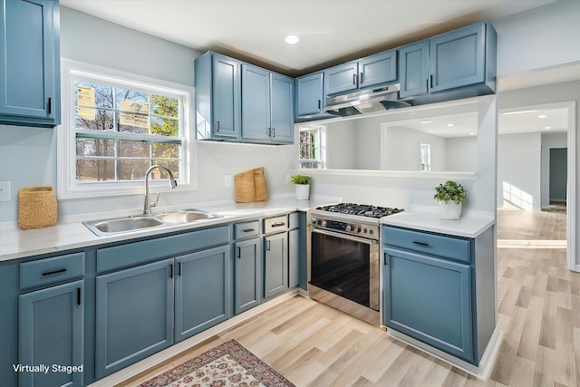 kitchen featuring sink, light hardwood / wood-style flooring, blue cabinetry, and gas stove