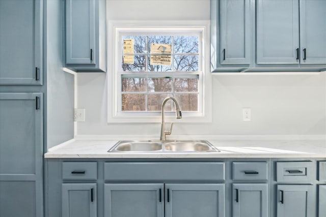 kitchen featuring light stone counters and sink