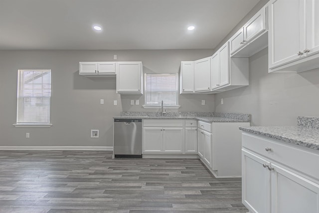 kitchen with dishwasher, plenty of natural light, sink, and white cabinets