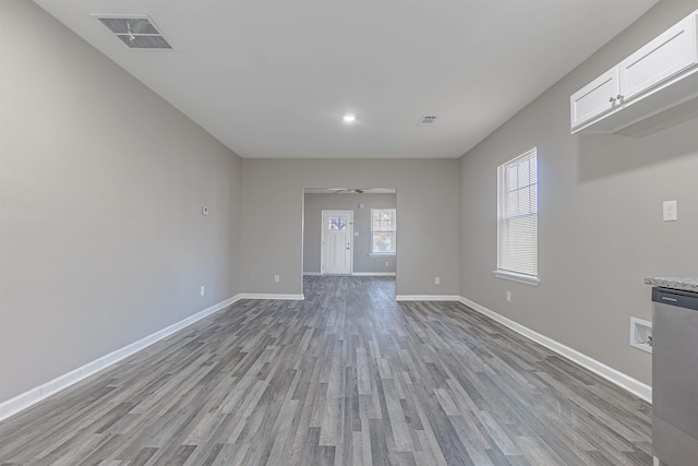 empty room with ceiling fan and light wood-type flooring