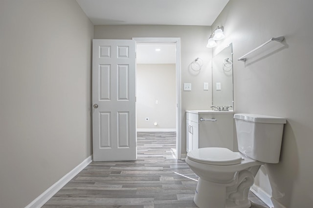 bathroom with vanity, hardwood / wood-style flooring, and toilet