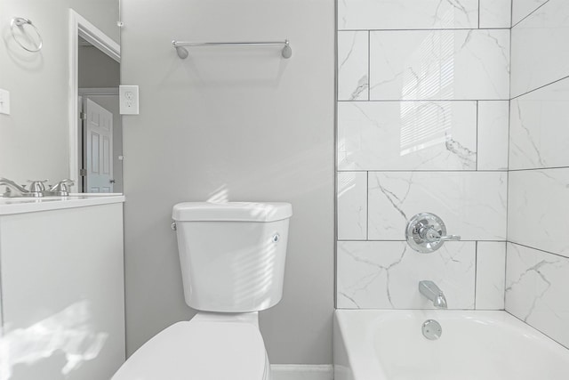 full bathroom featuring vanity, tiled shower / bath combo, and toilet