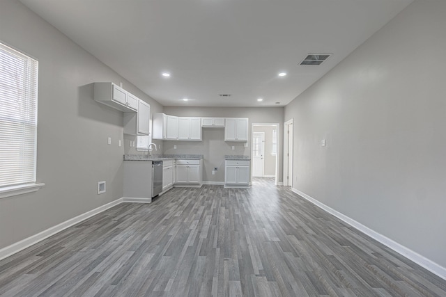 kitchen with white cabinetry, stainless steel dishwasher, hardwood / wood-style floors, and a wealth of natural light