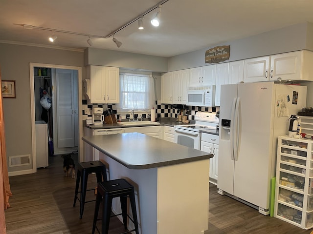 kitchen with white cabinetry, white appliances, sink, and a kitchen island