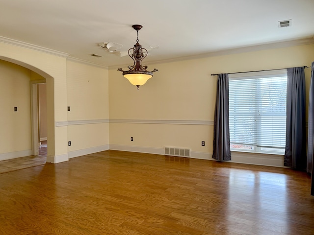 unfurnished room with ornamental molding and hardwood / wood-style floors