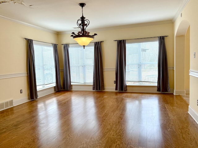 spare room featuring ornamental molding, plenty of natural light, and hardwood / wood-style floors